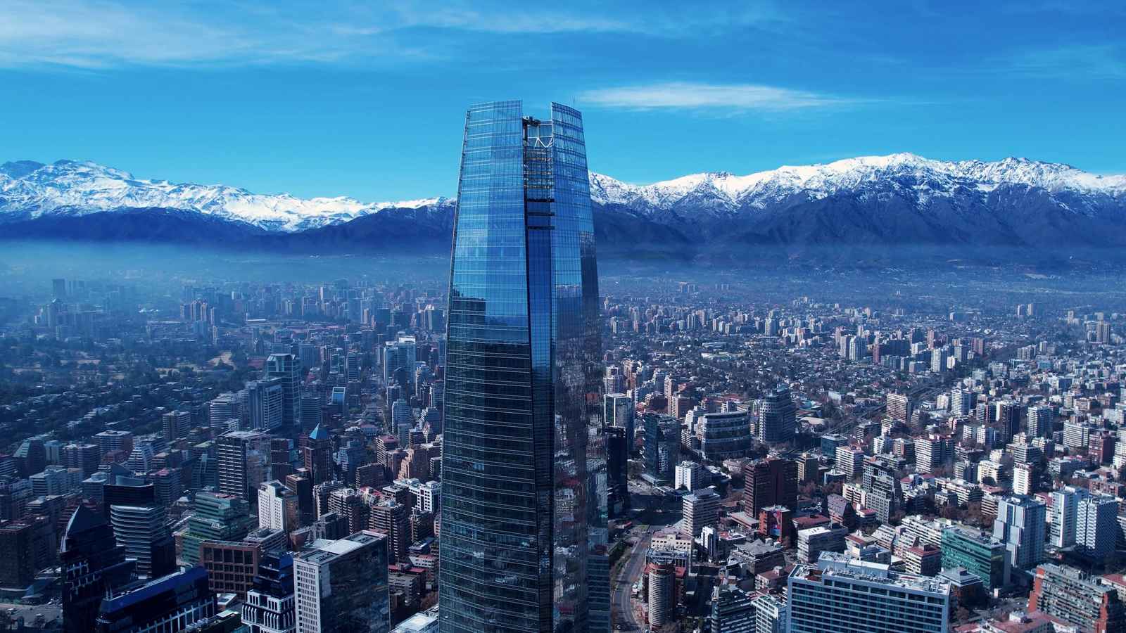 Gran Torre Santiago y edificios de la ciudad con la cordillera nevada al fondo, vistos desde el aire